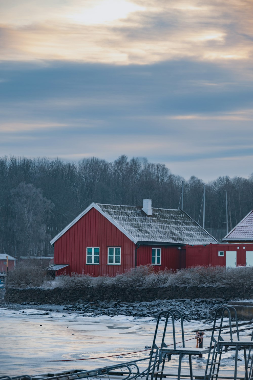 a red house sitting next to a body of water