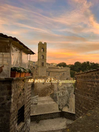 Lorenzo Muscoso directing a scene outdoors in a rustic Sicilian village at sunset, embodying the spirit of Verga’s world.