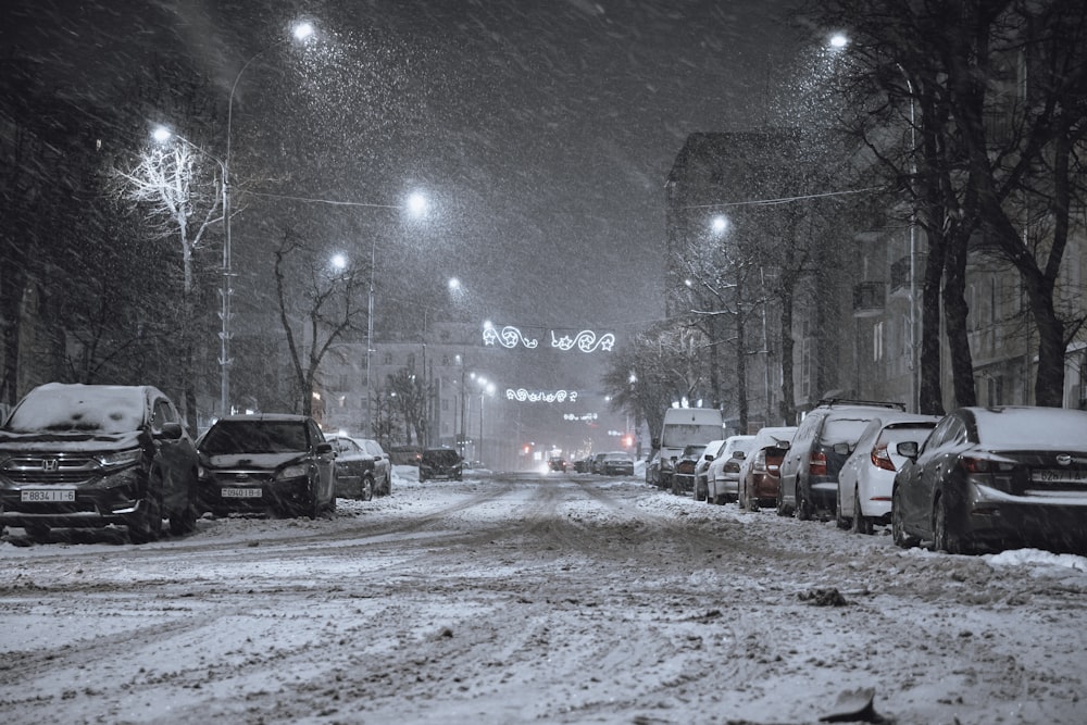 a snowy street with cars parked on the side of it