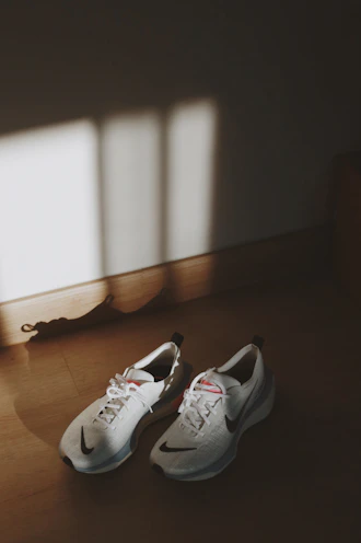 A pair of modern sneakers on a wooden floor with soft natural light