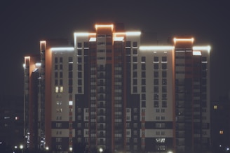 Night view of the building’s illuminated facade contrasted against a clear sky.