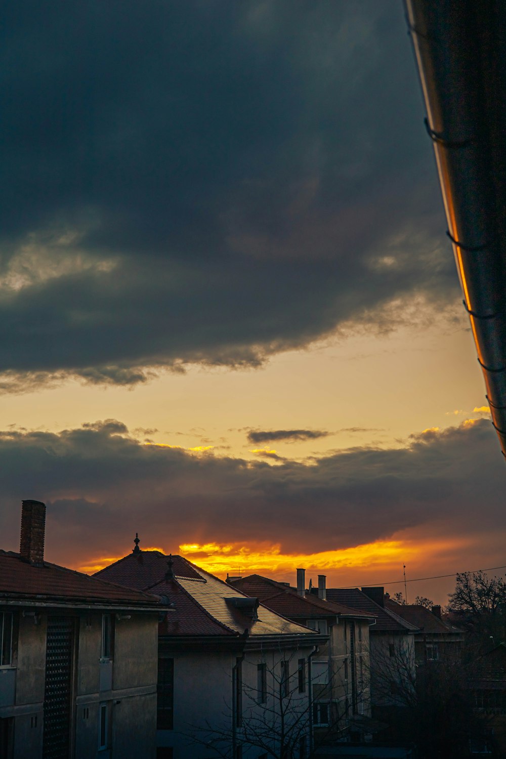 the sun is setting over a row of houses