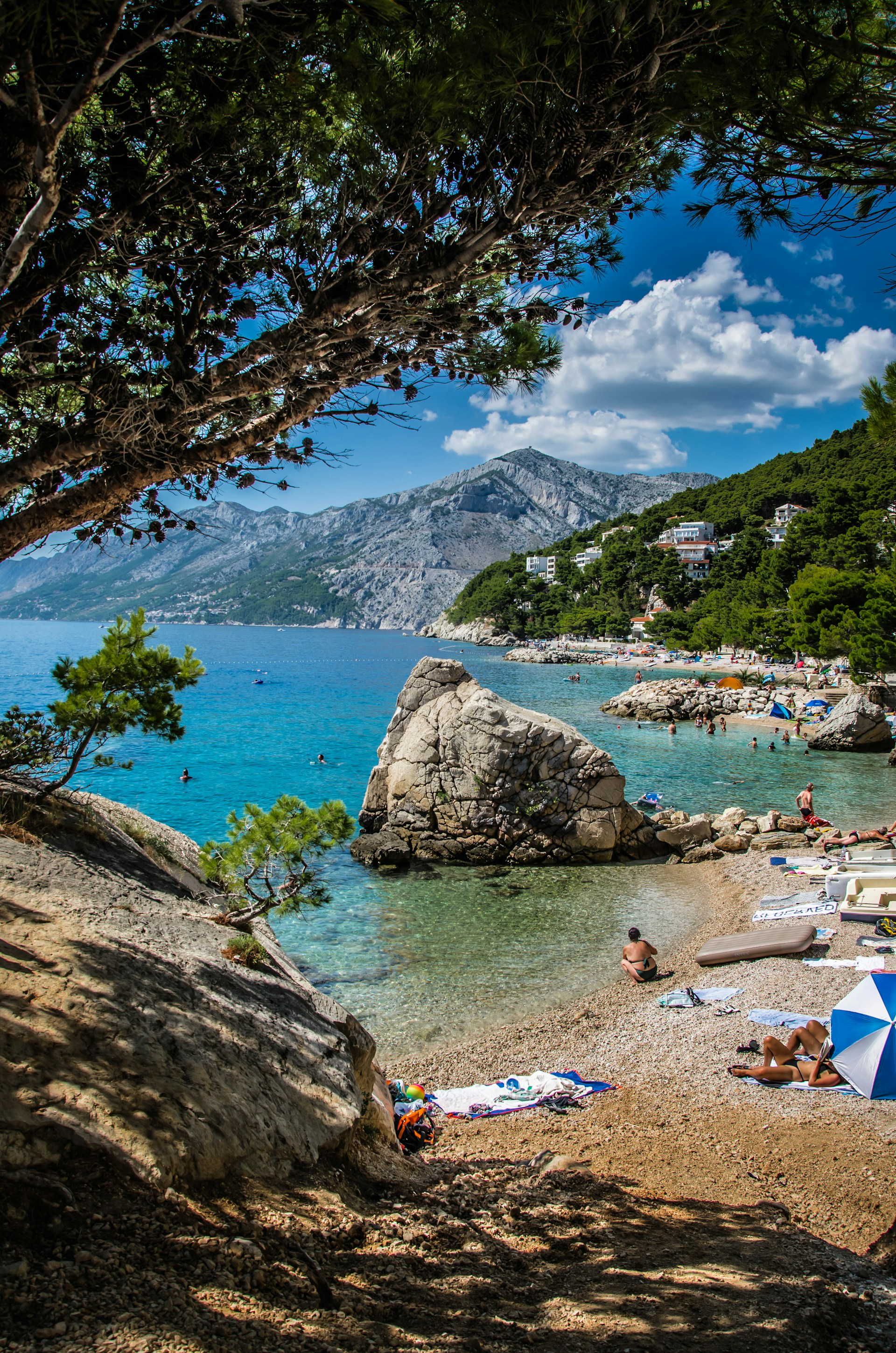 a beach with people laying on the sand and umbrellas