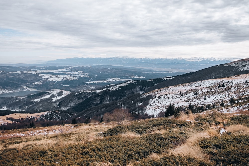 a view of a snowy mountain range from a hill