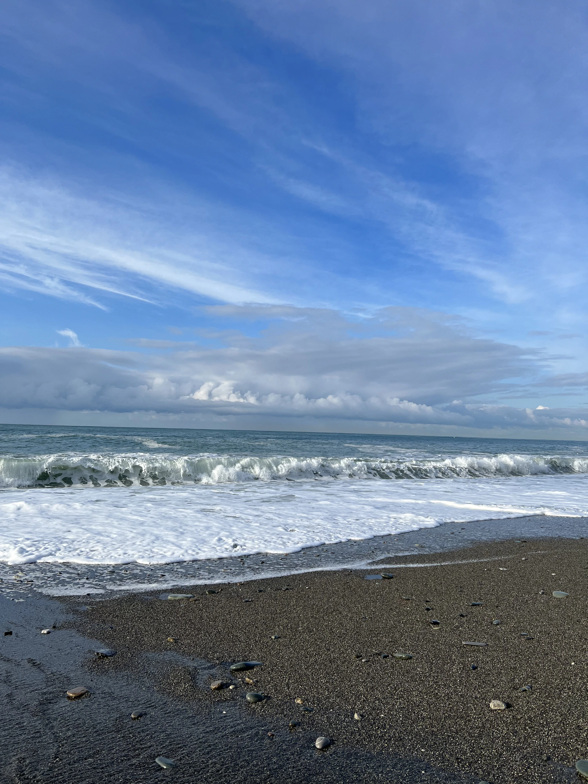 a sandy beach with waves coming in to shore