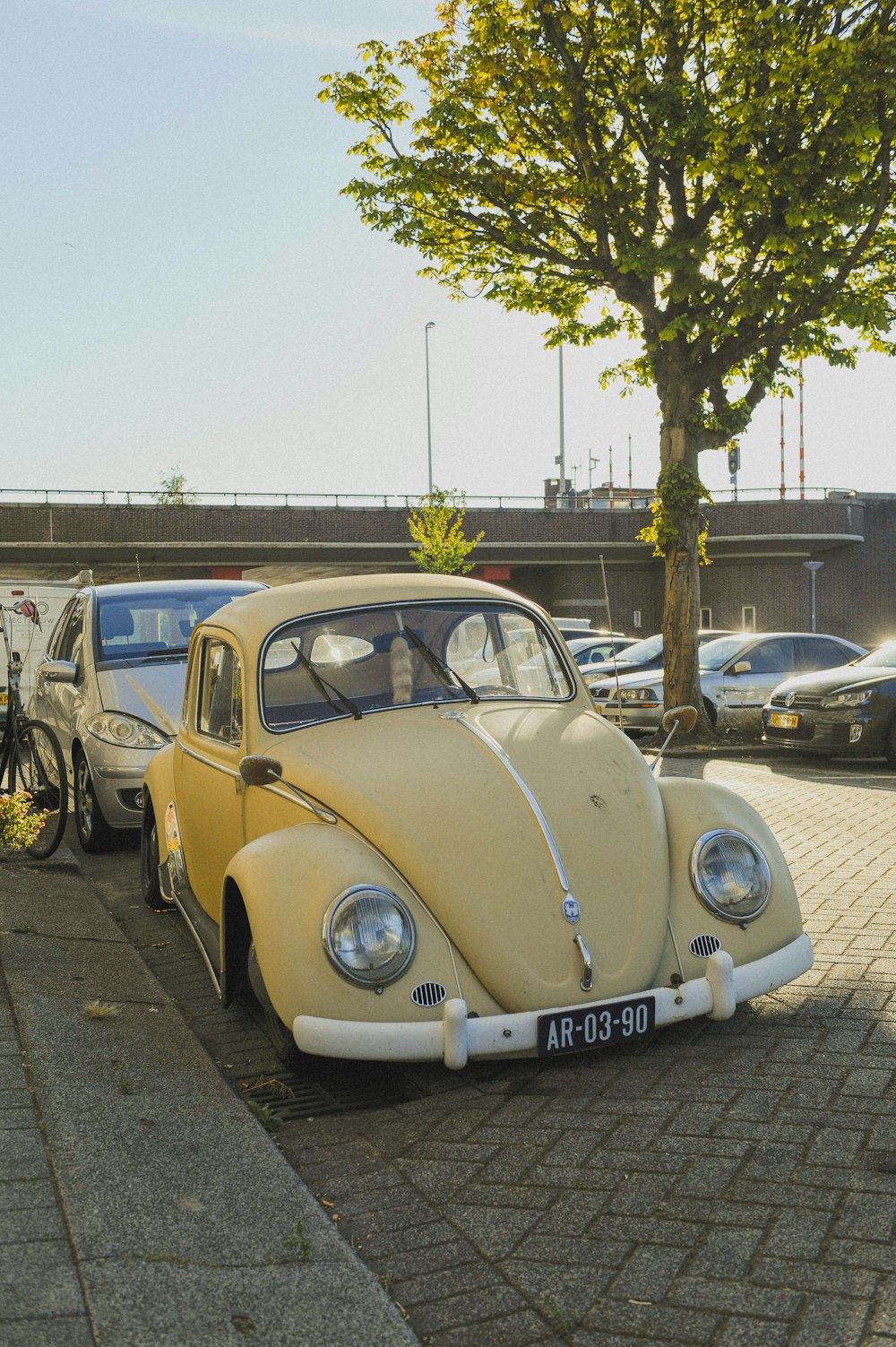 a yellow vw bug is parked on the side of the road