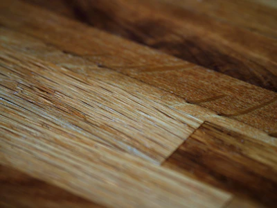 Close-up of hands crafting a wooden cabinet, highlighting the texture and detail of the wood grain.