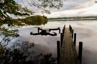 Drone hovering above a quiet lake reflecting the sunset.