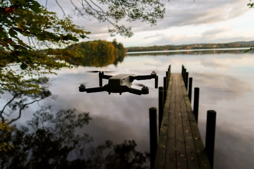 Drone hovering above a quiet lake reflecting the sunset.