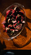 Rich red beet juice poured into a glass with fresh beets and greens around