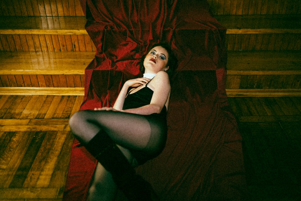 a woman laying on a red sheet in a room