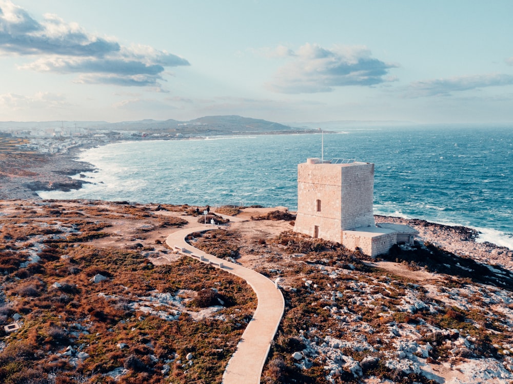 a stone tower sitting on top of a hill next to the ocean