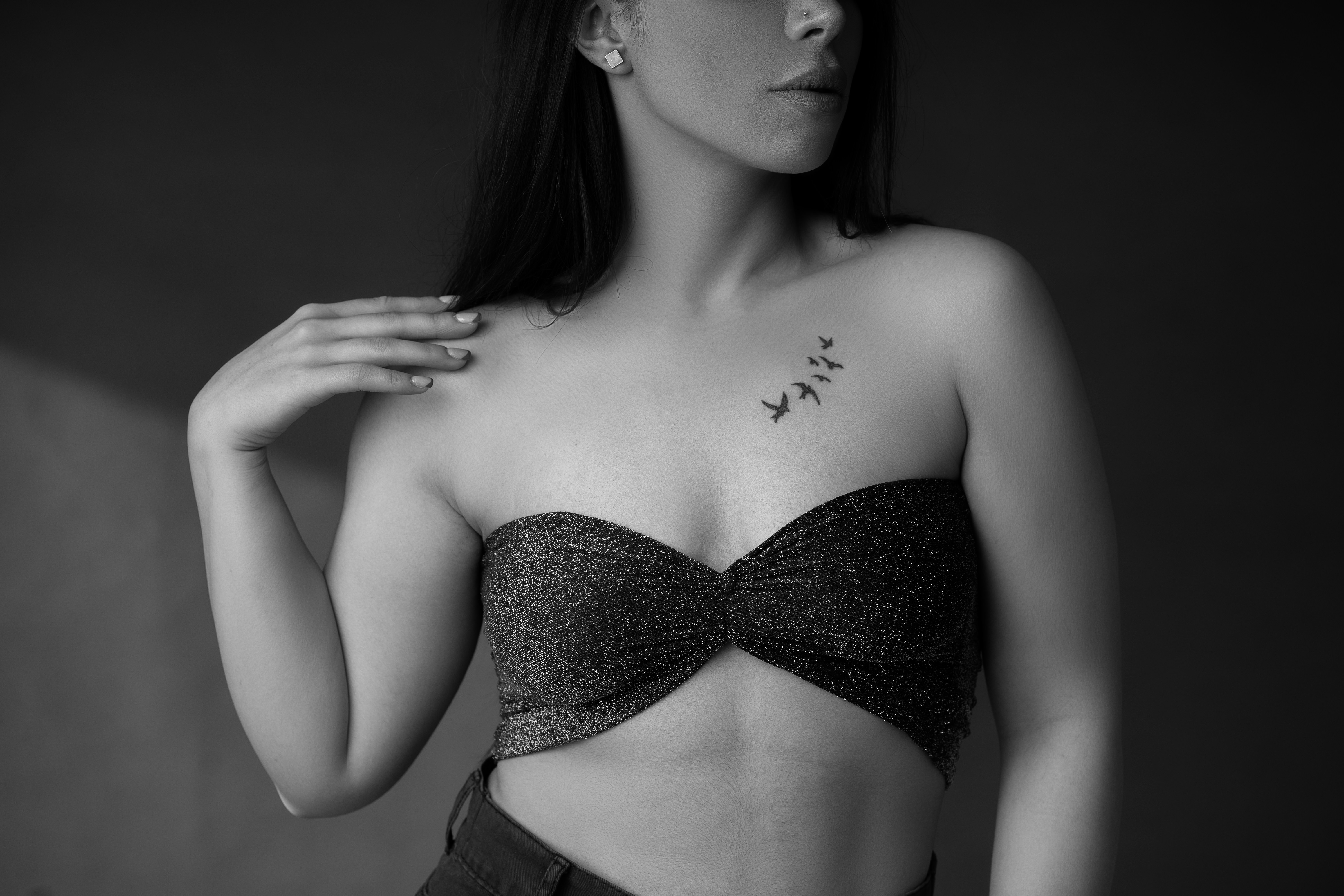 a black and white photo of a woman with a tattoo on her chest