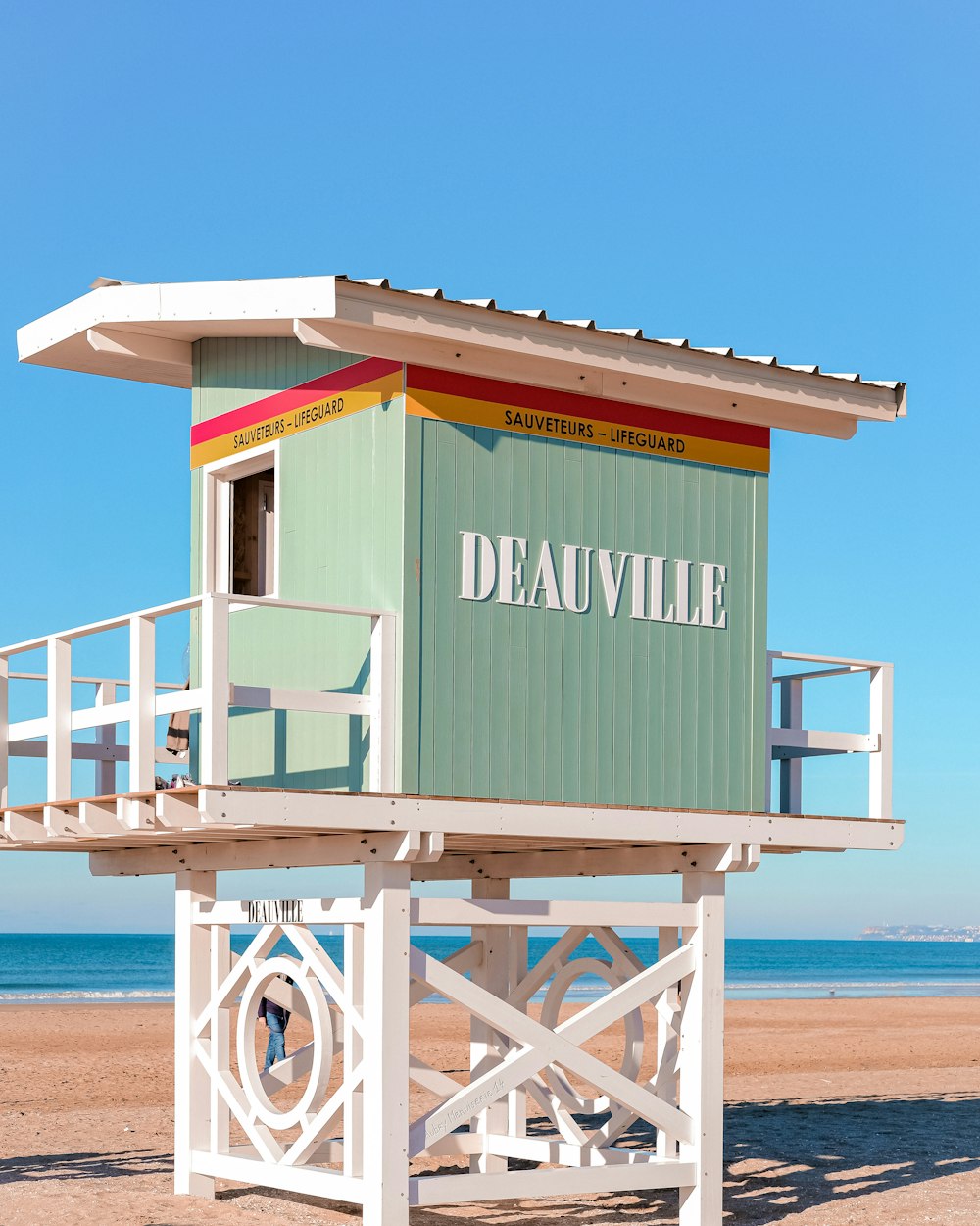 a lifeguard stand on the beach with a blue sky in the background