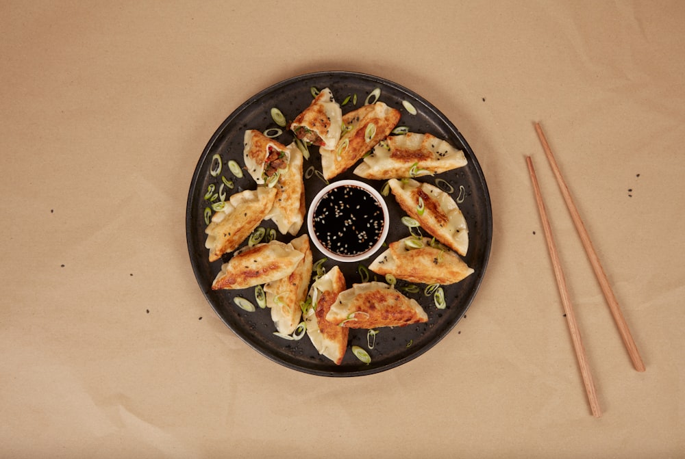 Un plato de comida y palillos sobre una mesa