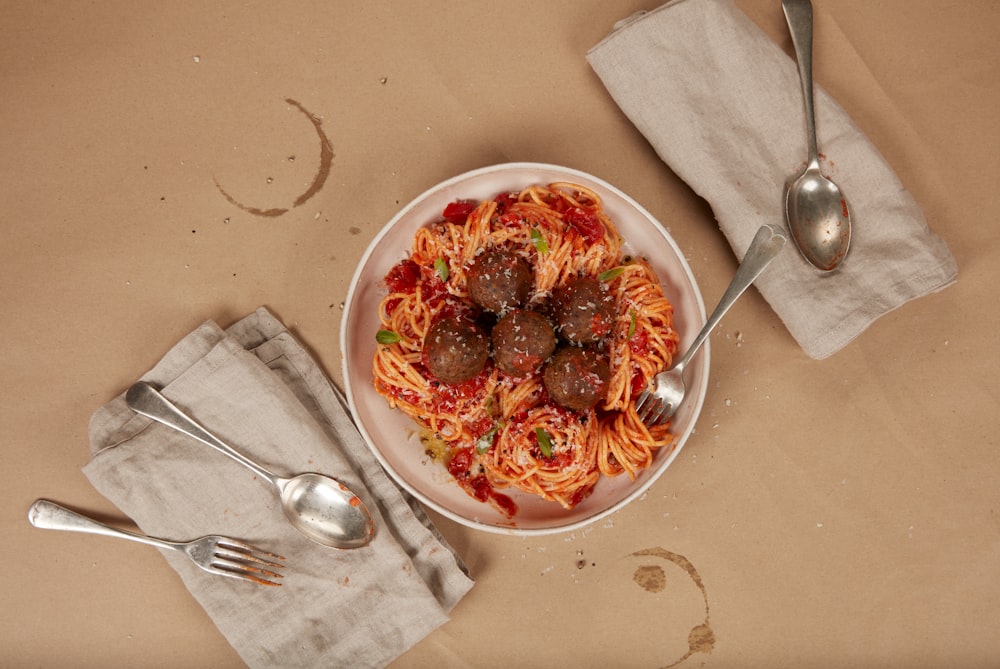 Un plato de espaguetis con albóndigas y salsa