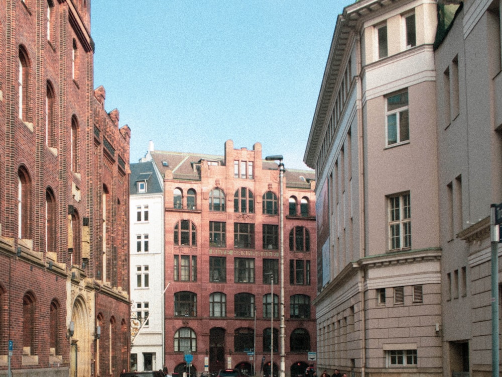 a group of people walking down a street next to tall buildings