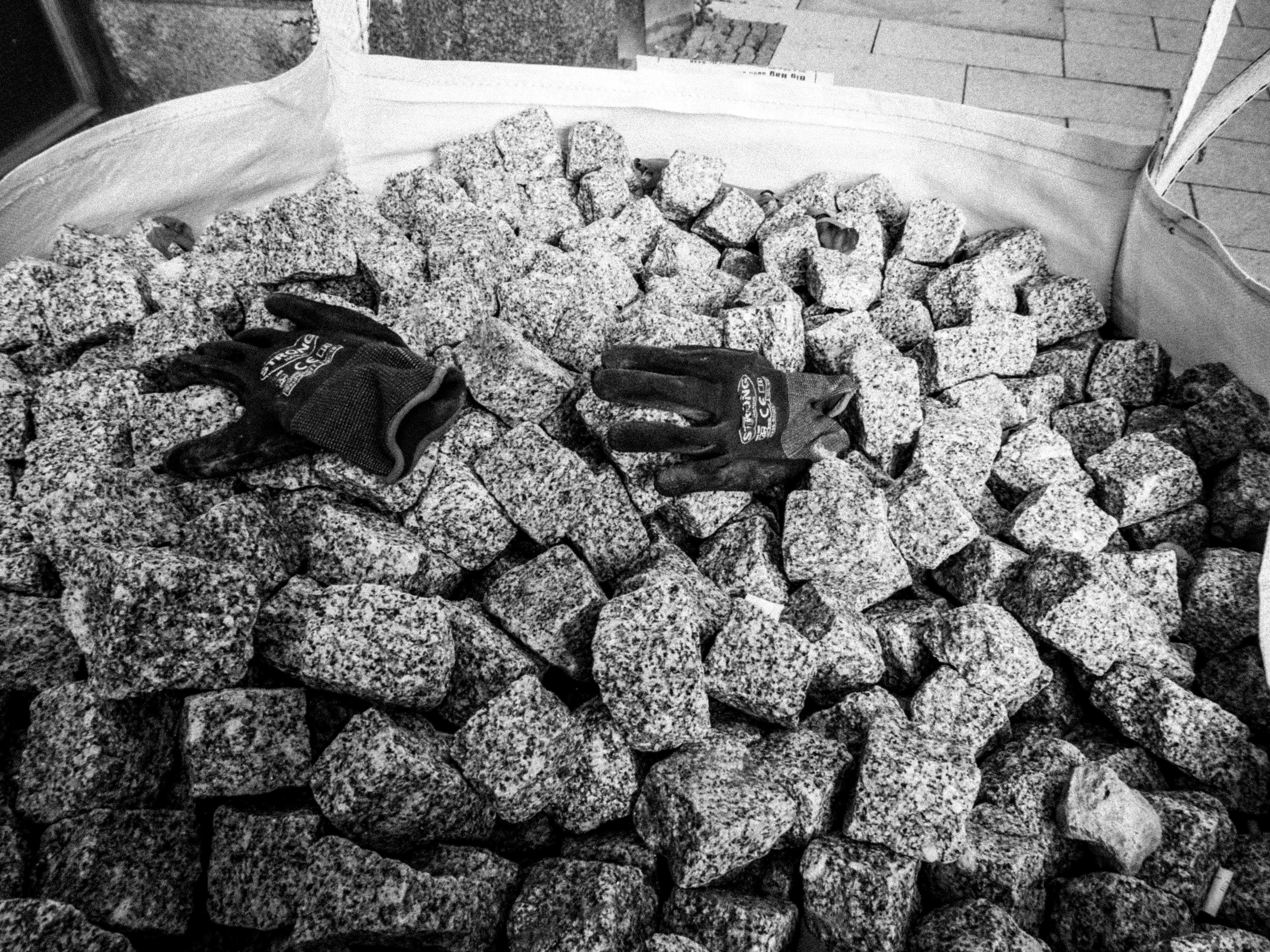 a pile of black and white rocks and gloves