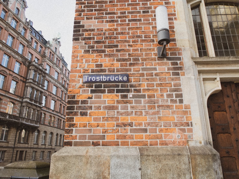 a brick building with a street sign on it