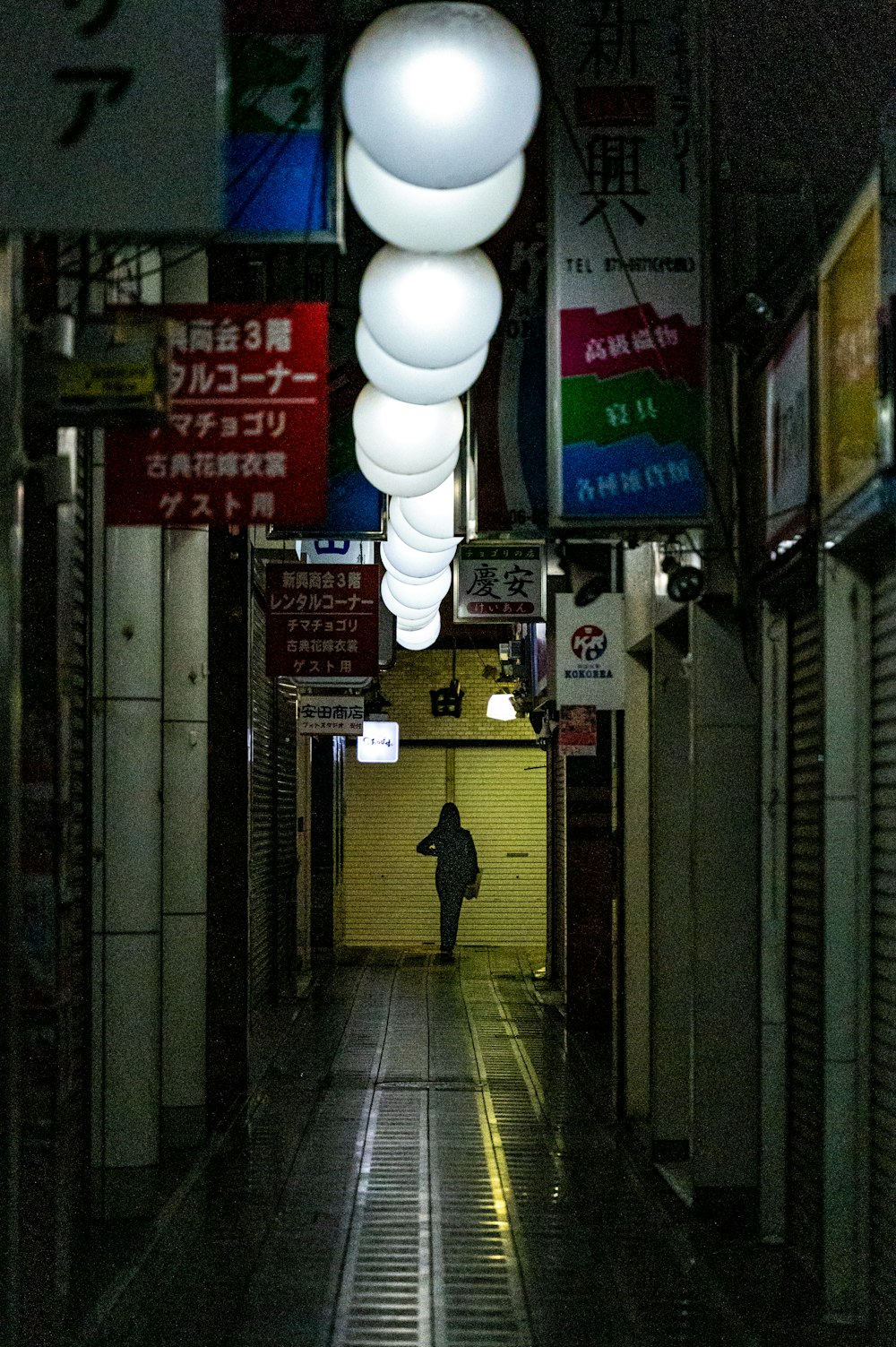 une personne marche dans une ruelle sombre