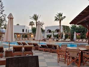 A luxurious poolside view with comfortable seating and gardens.