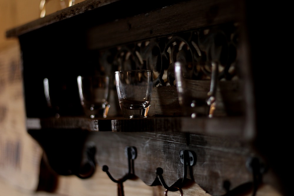 a row of wine glasses sitting on top of a wooden shelf