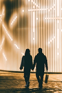Lifestyle shot of a couple strolling at dusk, dressed in Lumina’s chic evening wear.