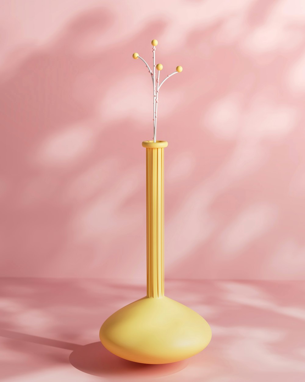 a yellow vase with a branch in it