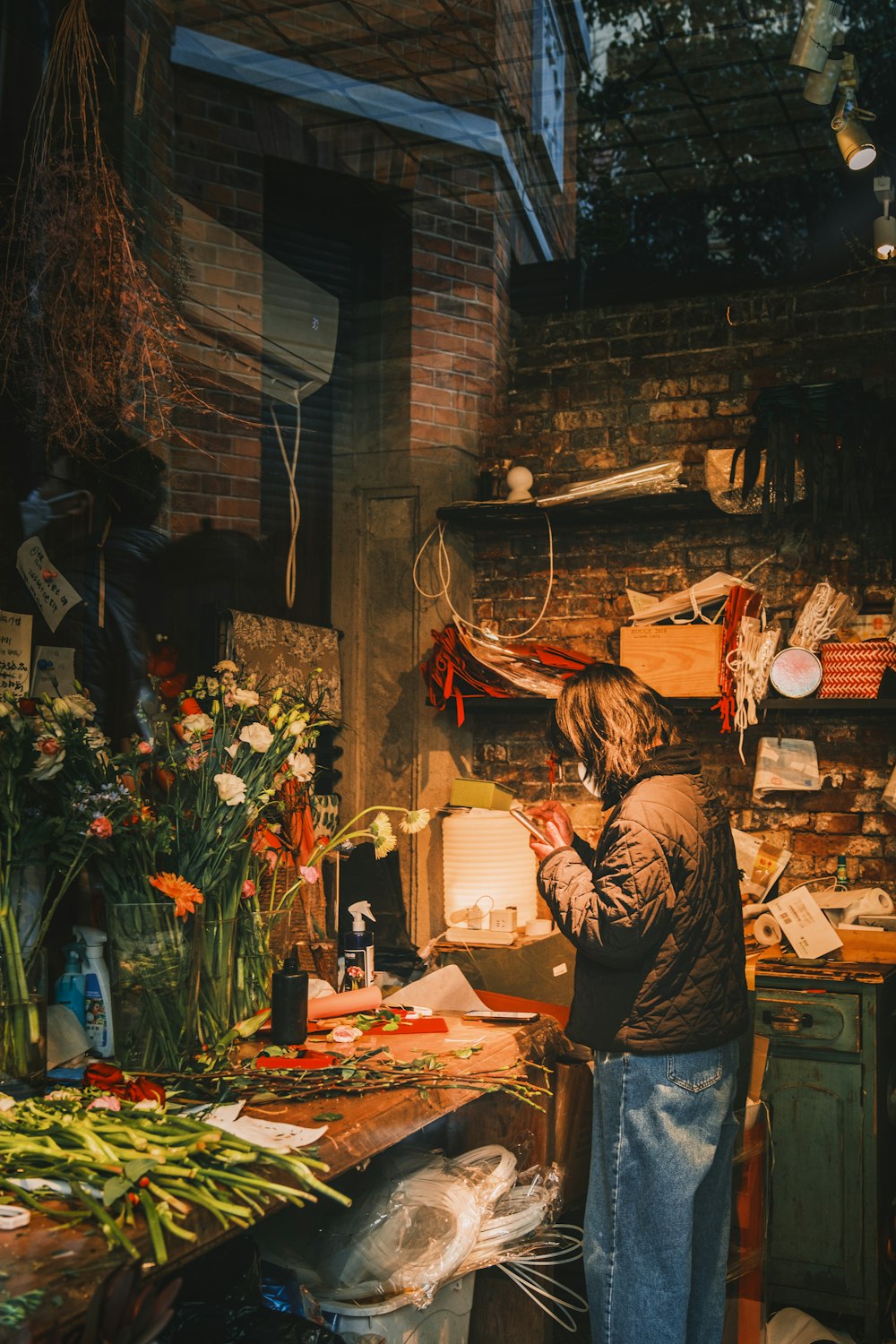 a woman standing in a kitchen next to a bunch of flowers