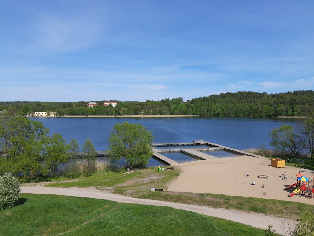 a large body of water sitting next to a lush green forest