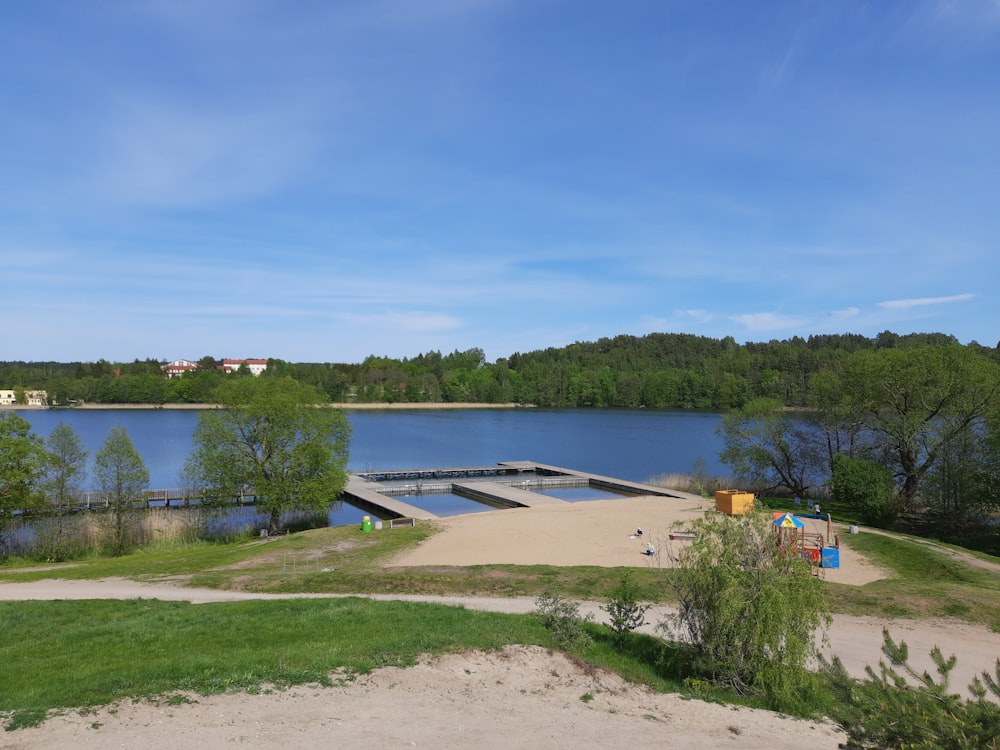 a large body of water sitting next to a lush green forest