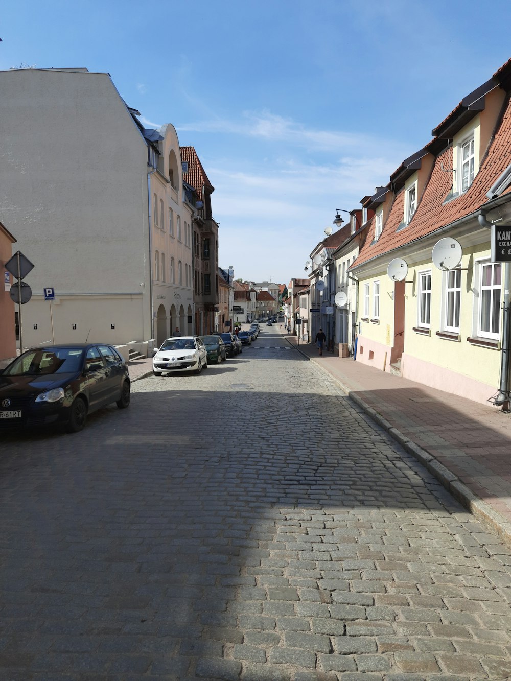 a car is parked on a cobblestone street