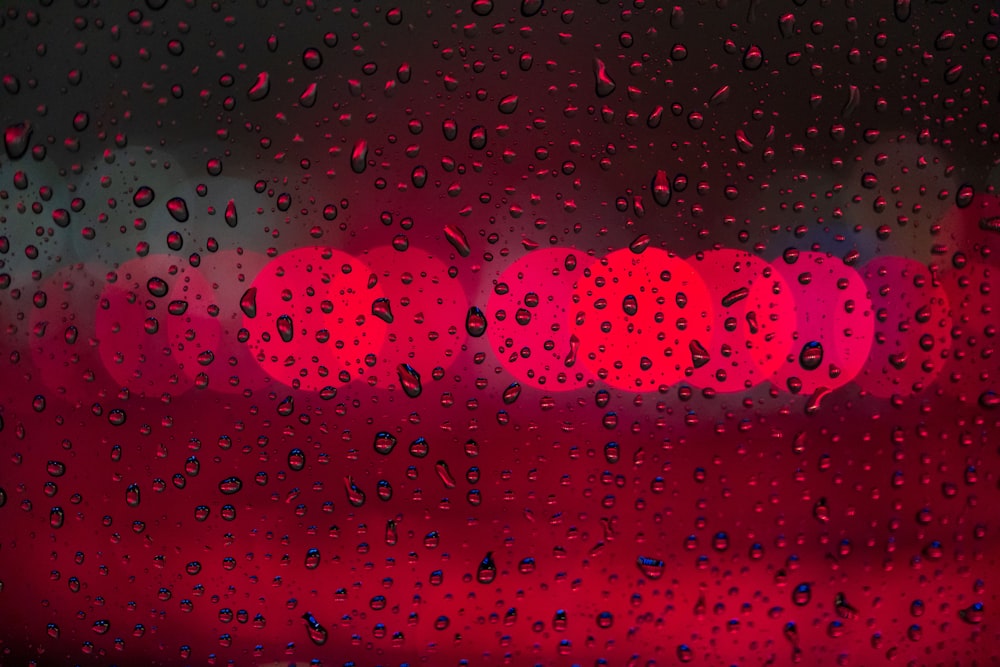 a red traffic light seen through a rain covered window