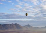 a hot air balloon flying over a mountain atlas mountains