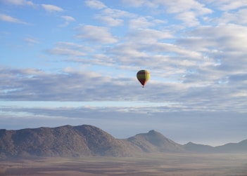 a hot air balloon flying over a mountain atlas mountains