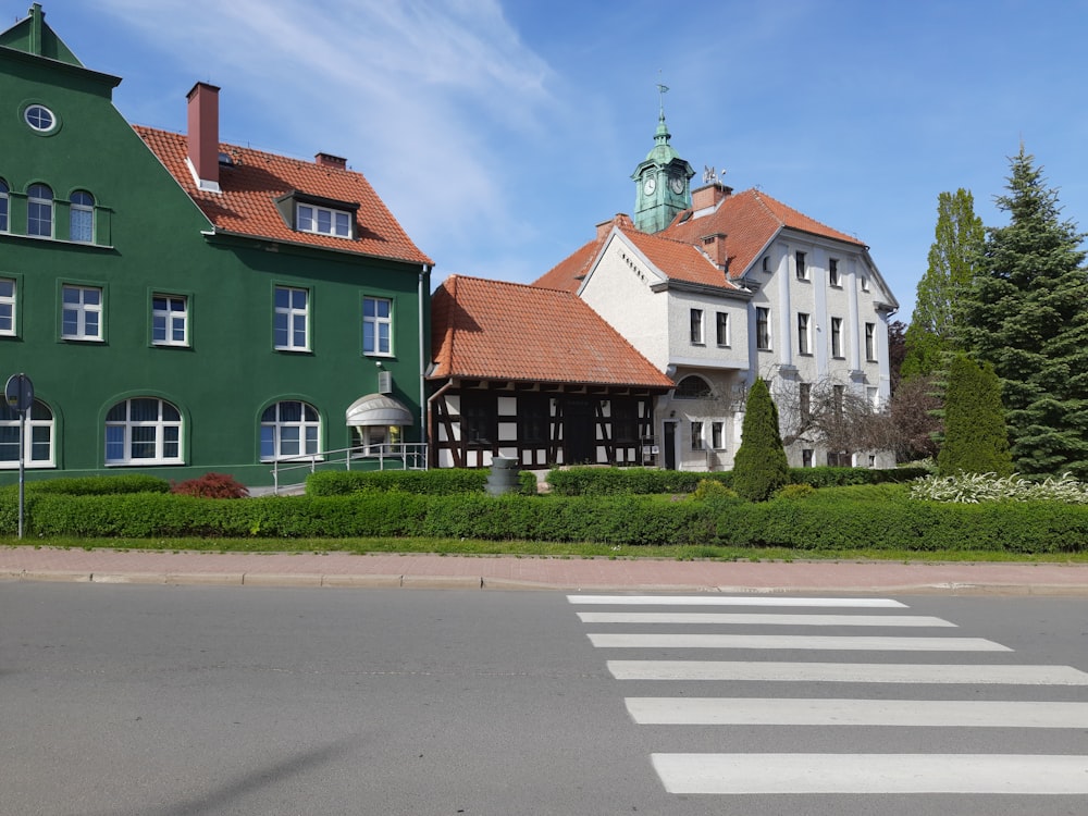 a cross walk in front of a green building