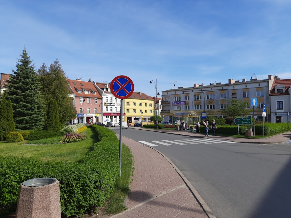 a blue and red street sign sitting on the side of a road