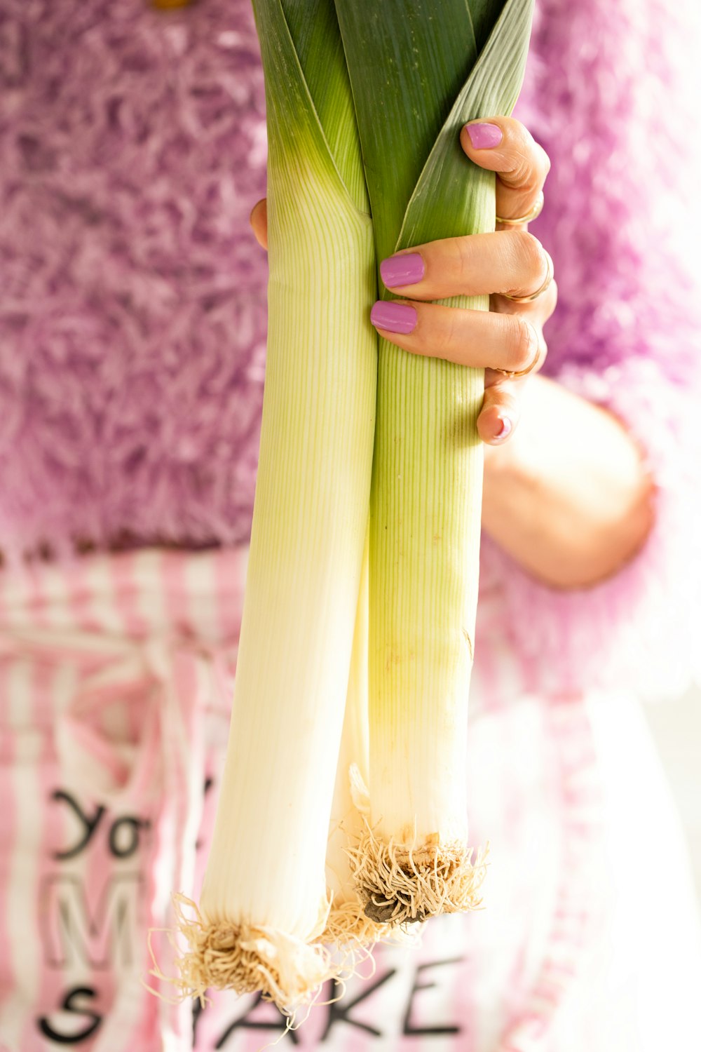 a close up of a person holding a stalk of celery