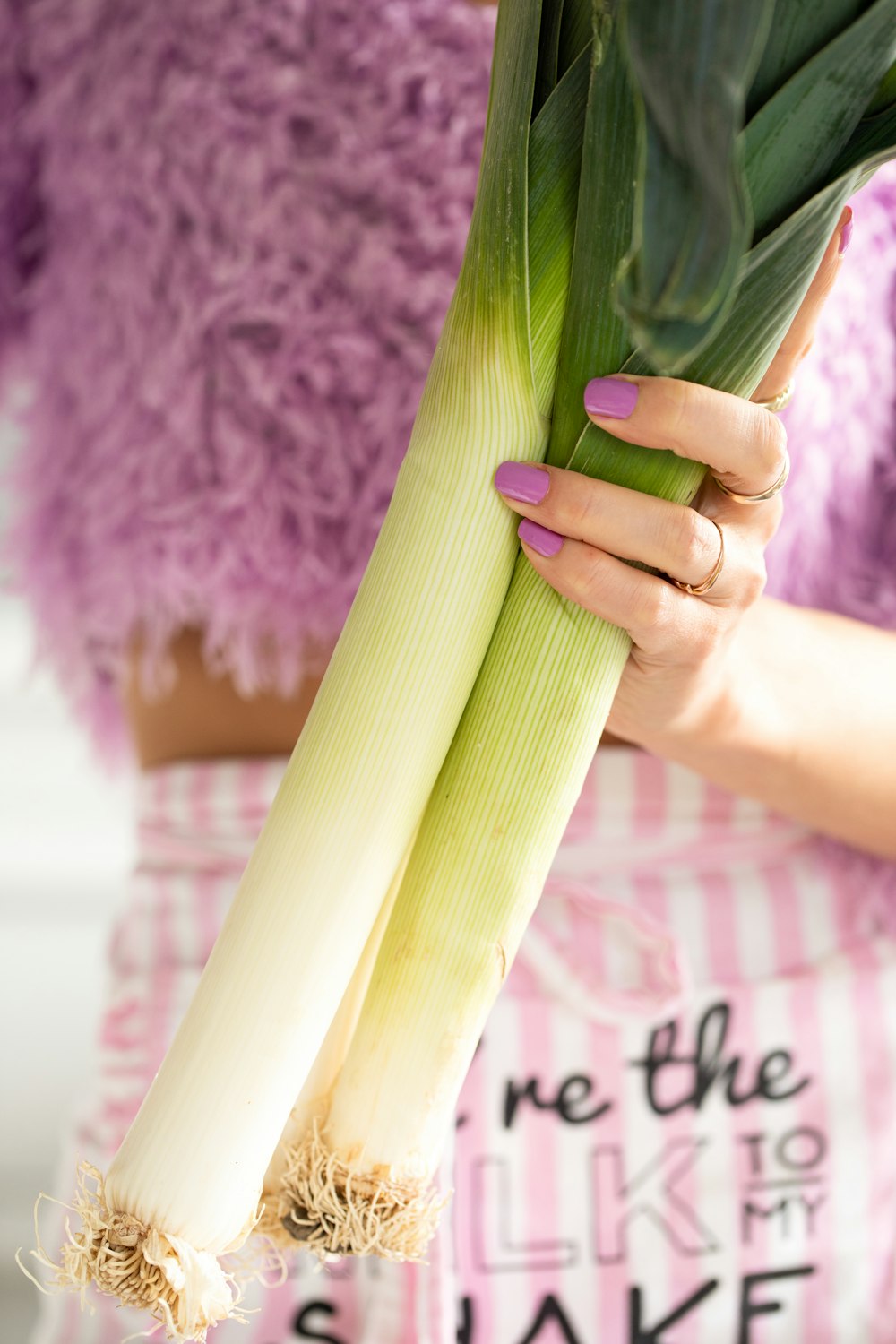 a woman holding a stalk of celery in her hands