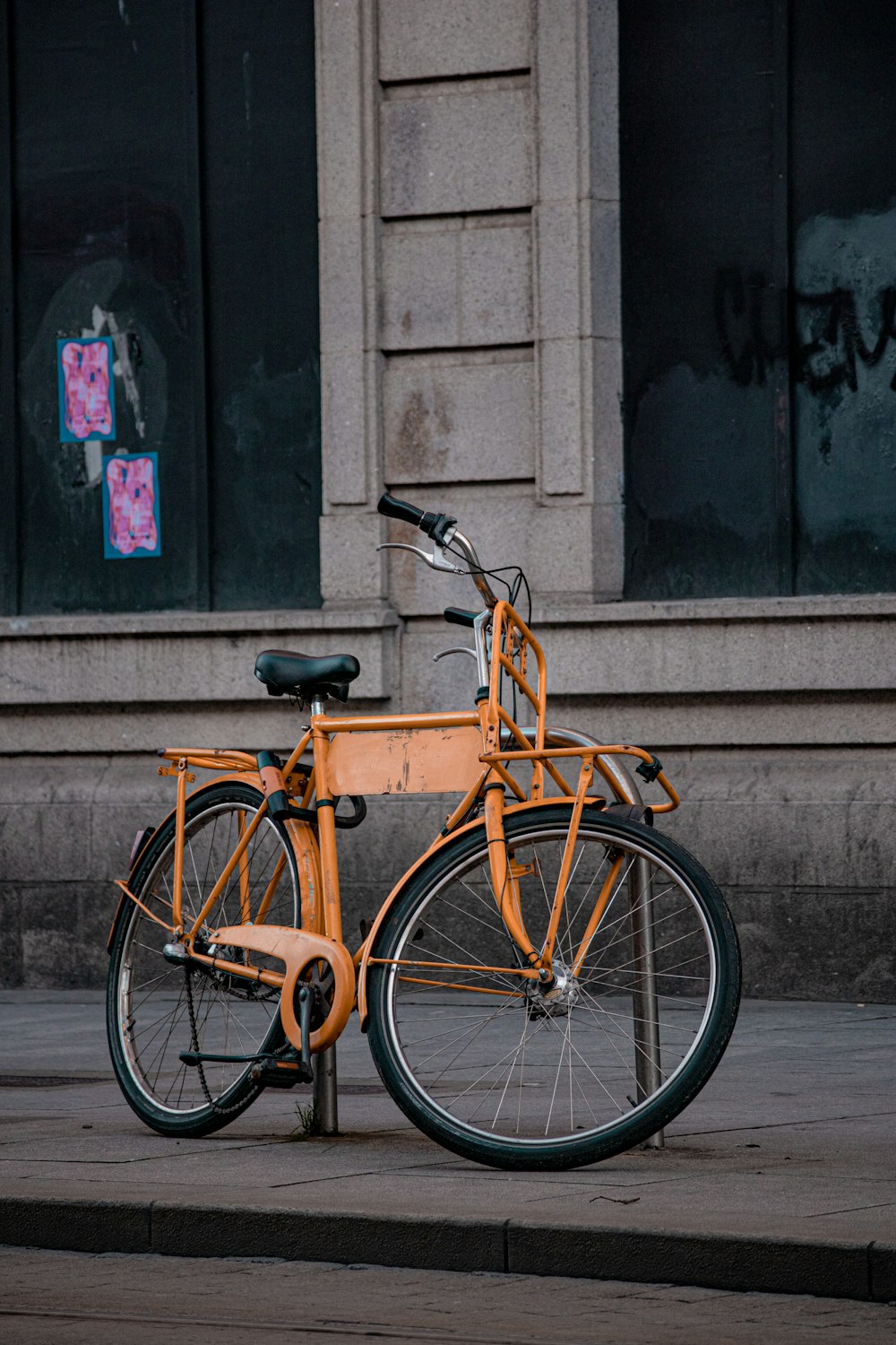 an orange bike parked on the side of a street