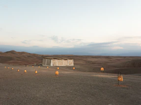 A serene Moroccan courtyard at sunset with lanterns glowing softly.