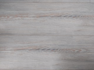 Close-up of luxury vinyl plank flooring with a wood grain finish in a kitchen.