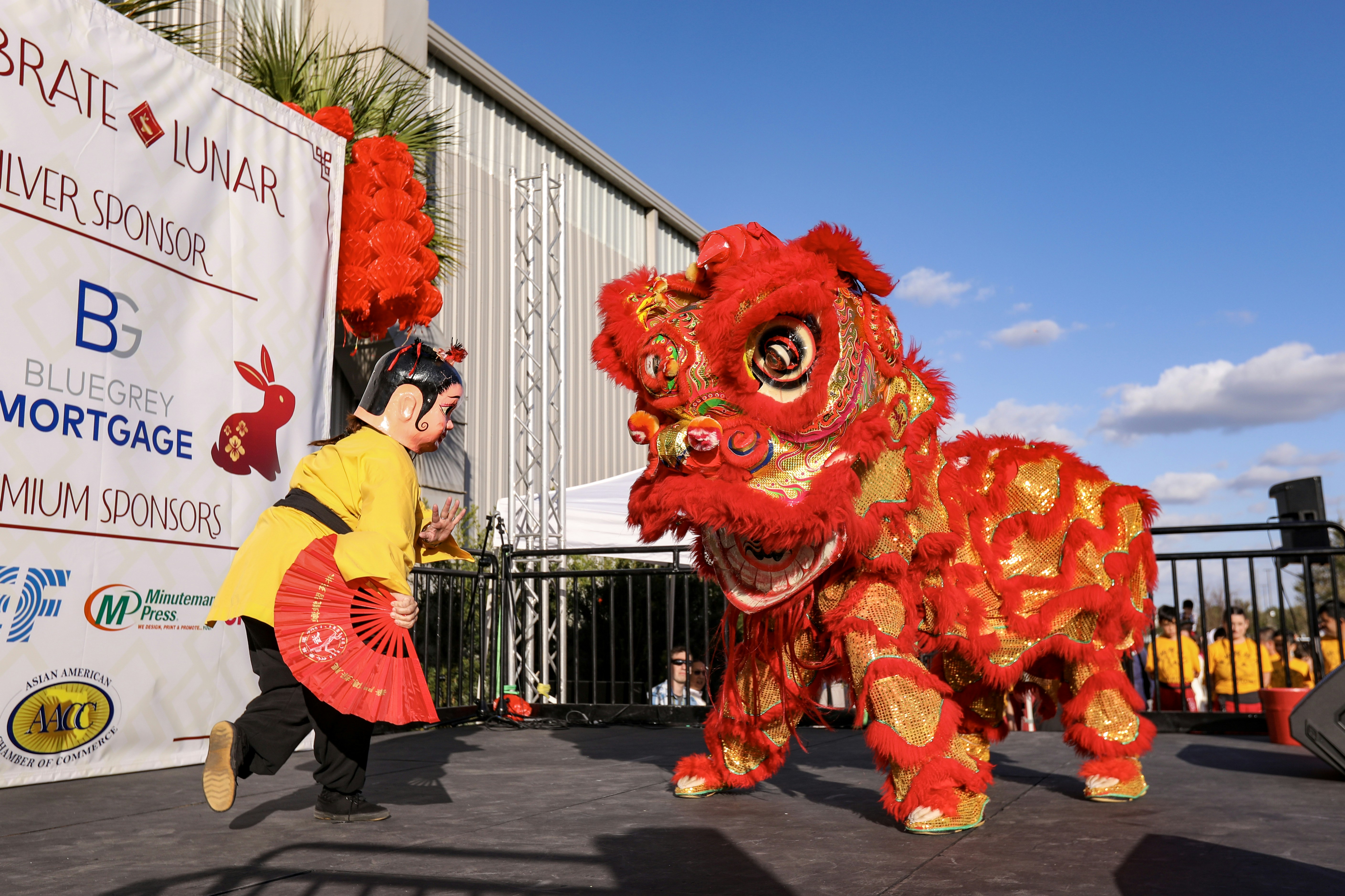 a young boy standing next to a red and yellow lion