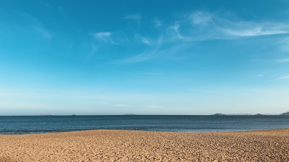 a sandy beach with a body of water in the background