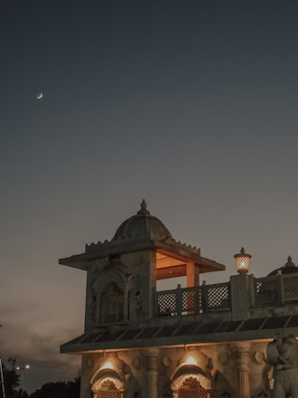 A serene image of a traditional Hindu temple with soft golden light and lotus patterns in the background.