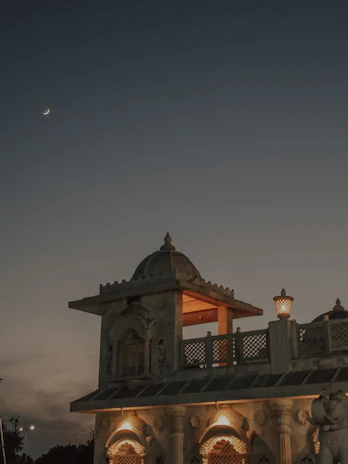 A peaceful evening view of the temple courtyard glowing with lamps.