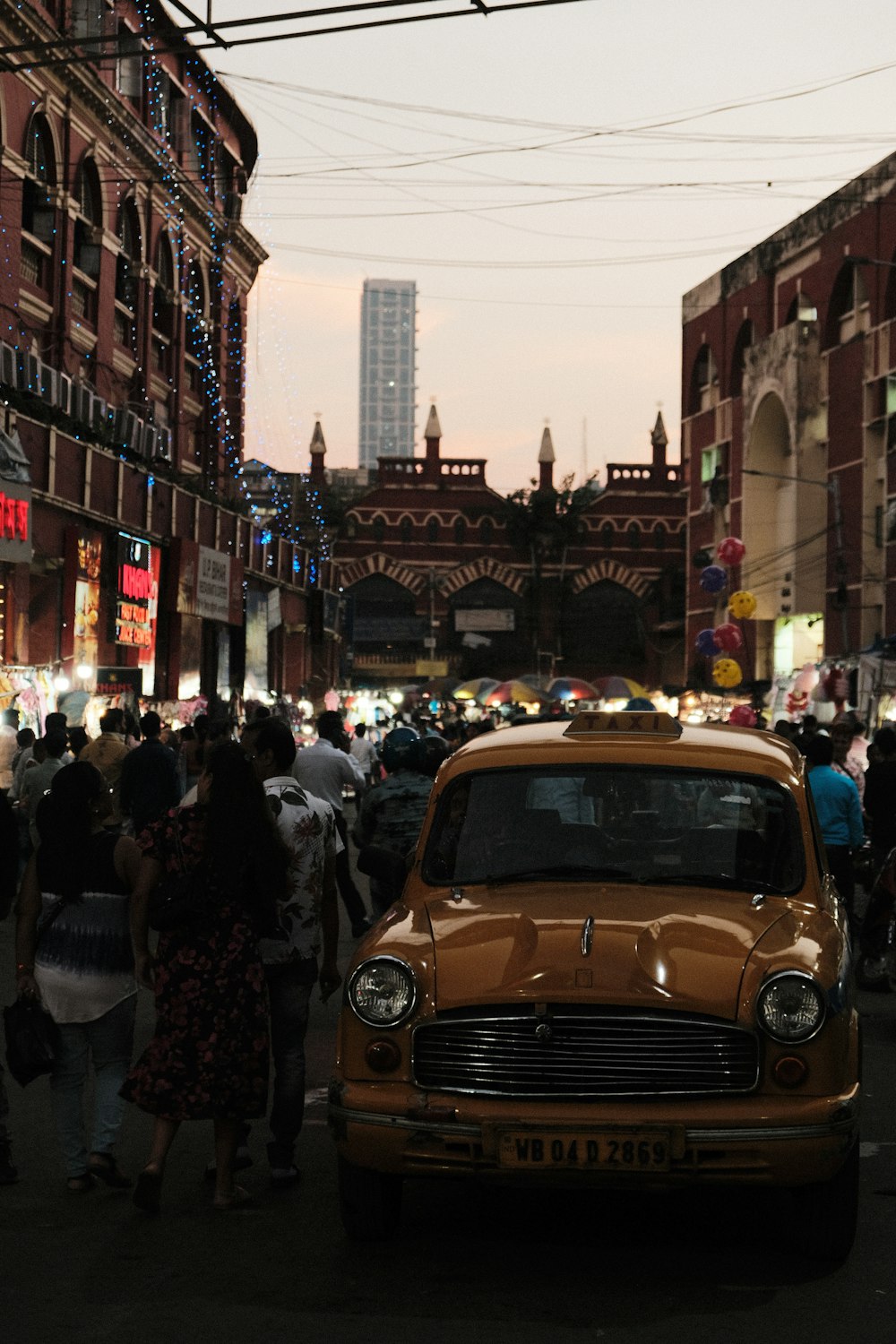 a yellow taxi cab driving down a street next to tall buildings