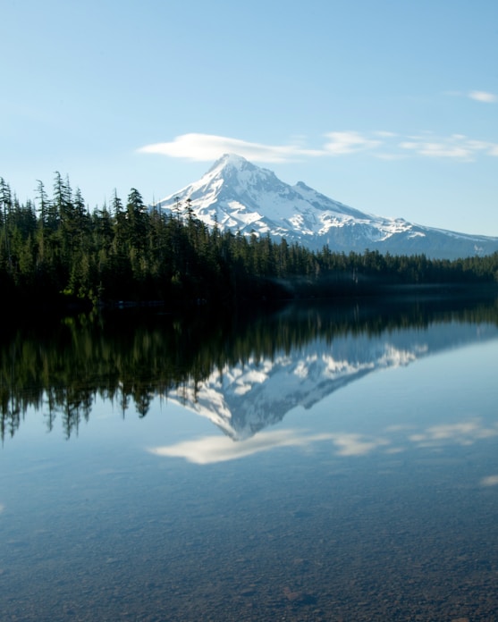 a mountain is reflected in the still water of a lake