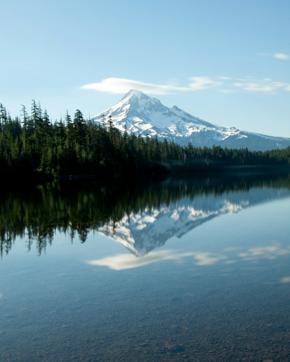 Ein Berg spiegelt sich im stillen Wasser eines Sees