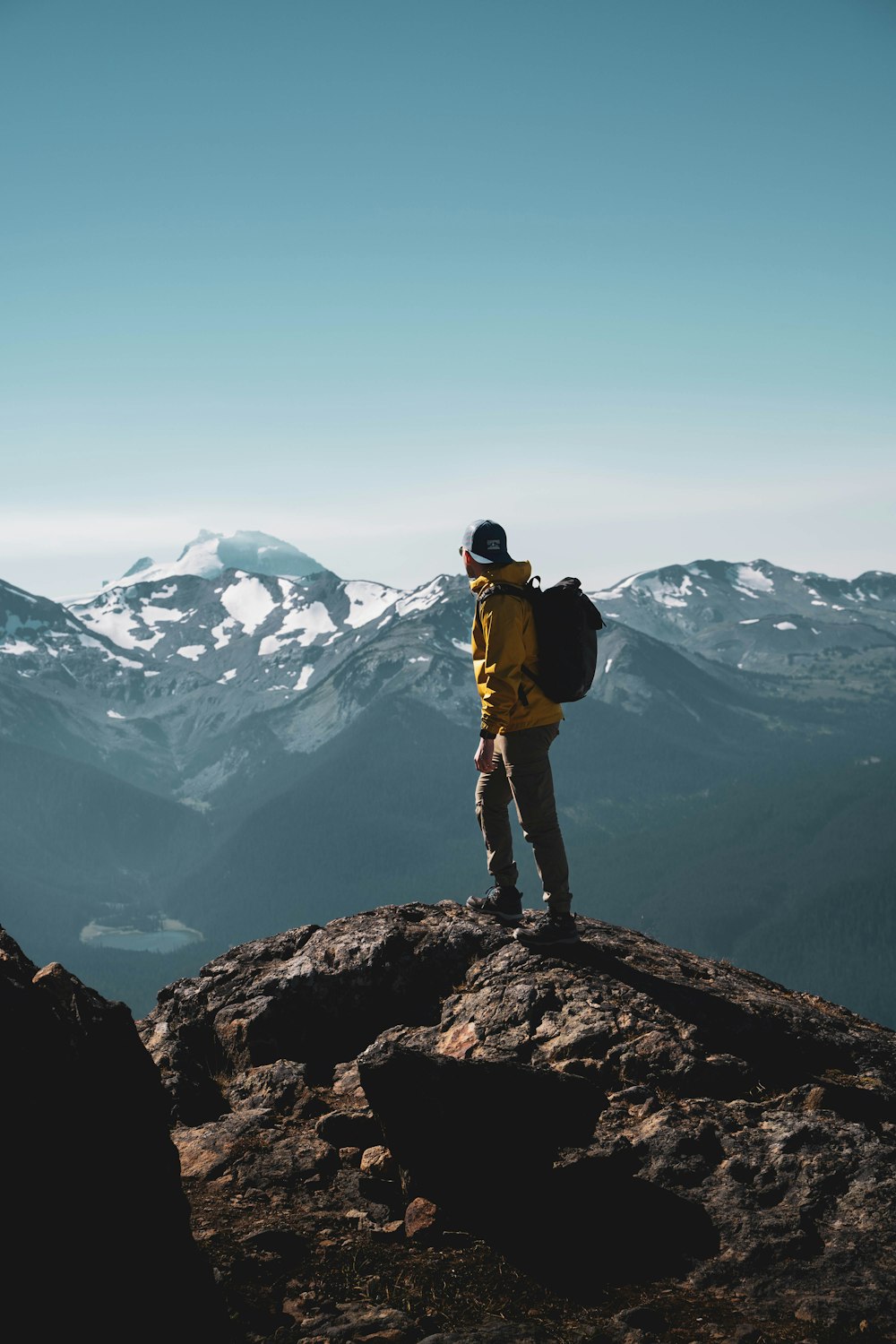 Ein Mann steht mit einem Rucksack auf einem Berg